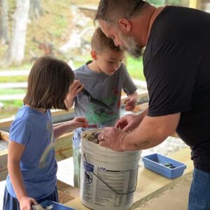 a father and two children sort through a gem bucket at Gem Mountain, searching for treasure