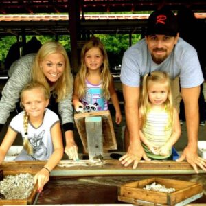 A family shows off their finds when flume mining for gemstones